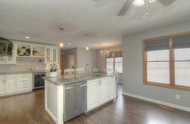 kitchen with a sink, beverage cooler, dishwasher, dark wood-style floors, and a kitchen island with sink