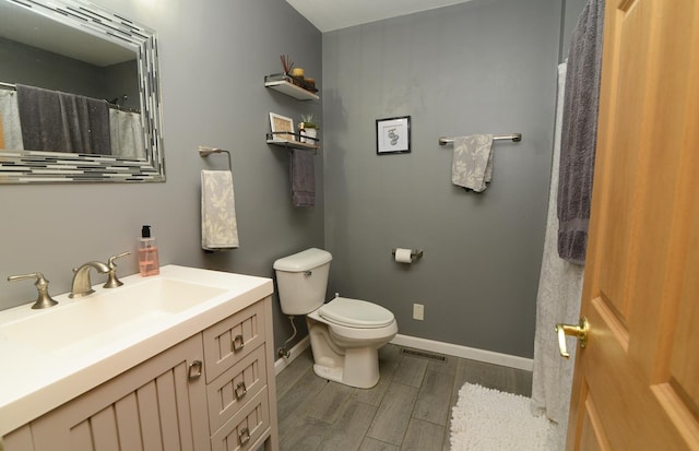 full bath with visible vents, toilet, wood finished floors, baseboards, and vanity