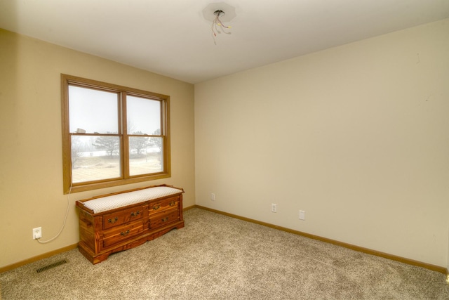 empty room with light colored carpet, visible vents, and baseboards