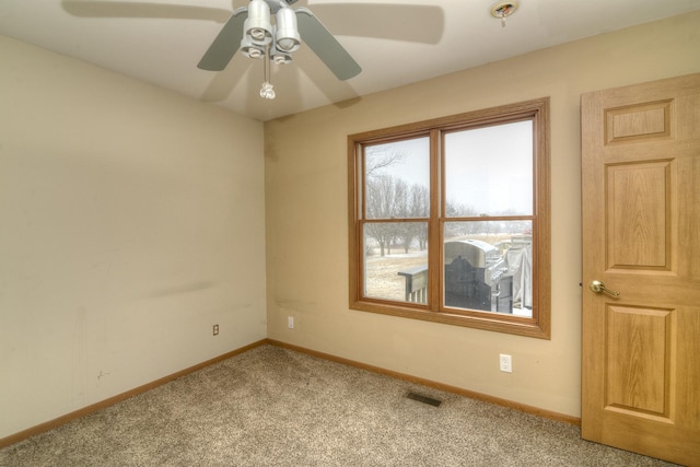 unfurnished room with visible vents, baseboards, a ceiling fan, and carpet flooring