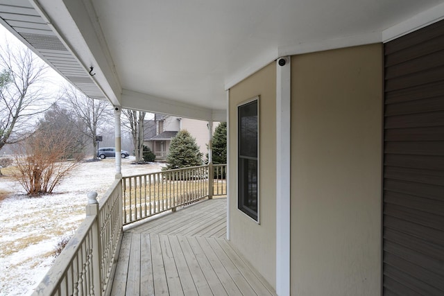 snow covered deck with a porch