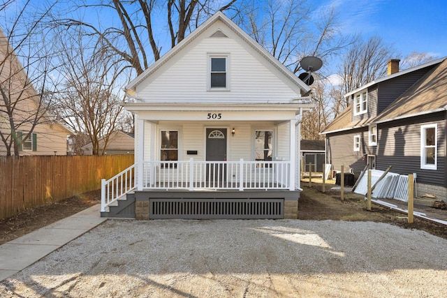 view of front facade featuring central air condition unit, covered porch, and fence