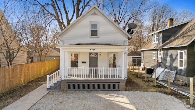 view of front of home with a porch and fence