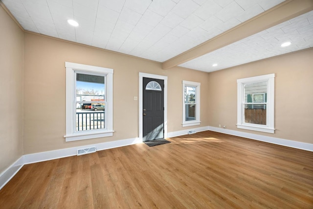 interior space with visible vents, plenty of natural light, baseboards, and wood finished floors