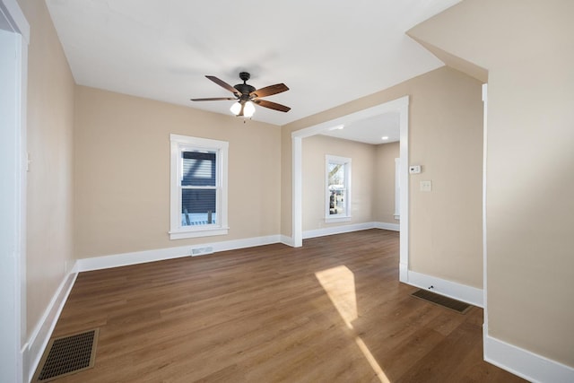 spare room featuring visible vents, baseboards, and wood finished floors