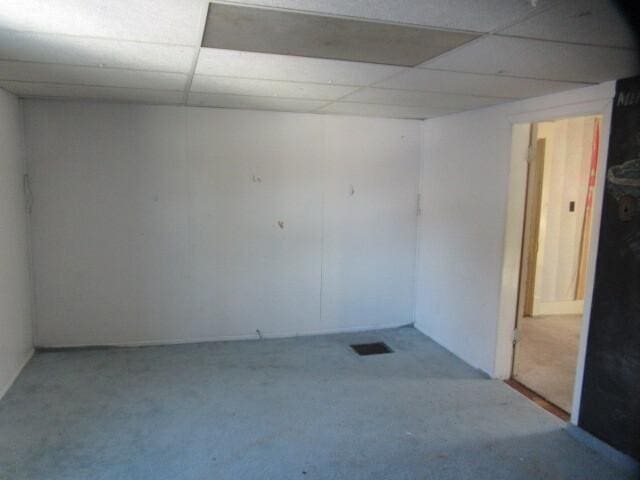 unfurnished room featuring a drop ceiling