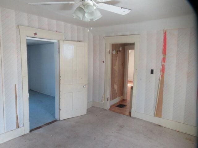 spare room with ceiling fan and unfinished concrete floors