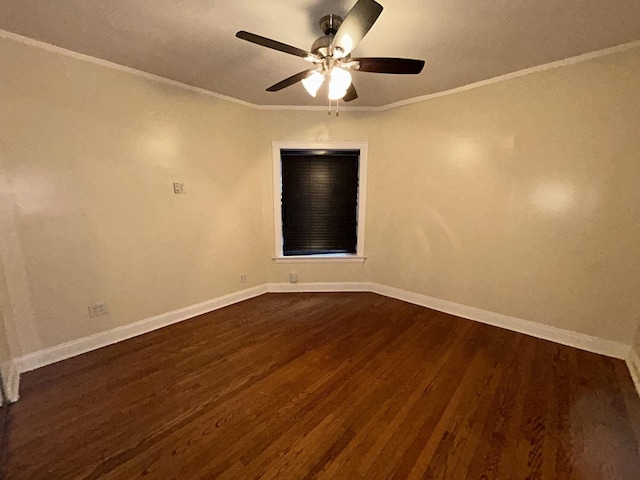 empty room with dark wood-style floors, baseboards, and crown molding