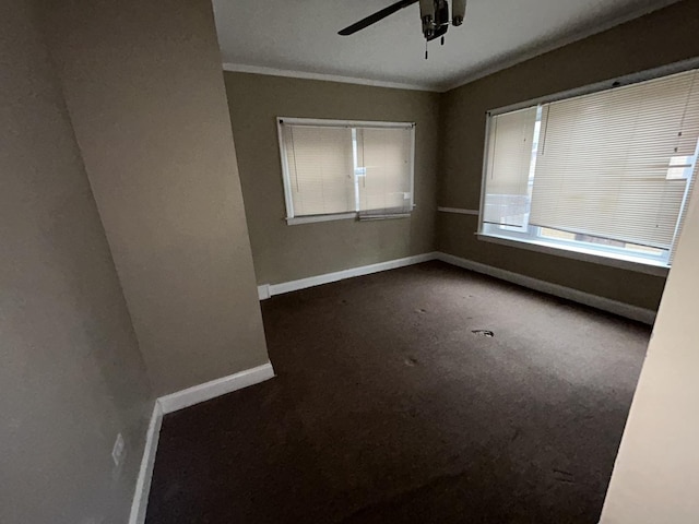 carpeted empty room featuring baseboards, a ceiling fan, and ornamental molding