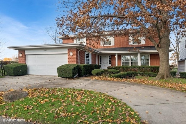 traditional-style home with a garage, brick siding, and concrete driveway