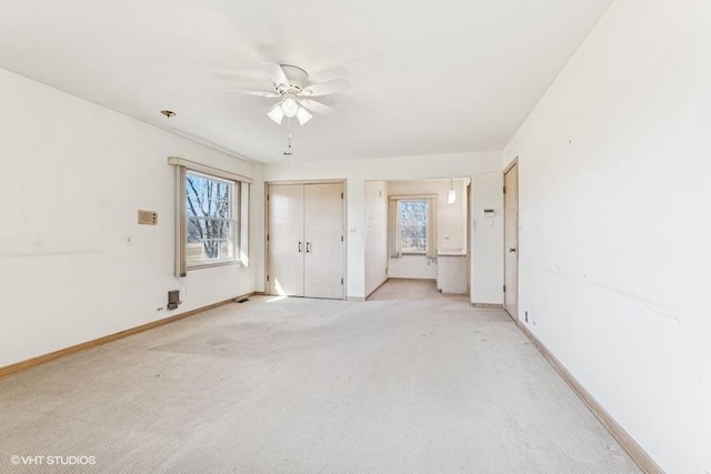 empty room with baseboards, light carpet, and ceiling fan