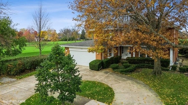 view of front of home with a front yard, an attached garage, brick siding, and concrete driveway