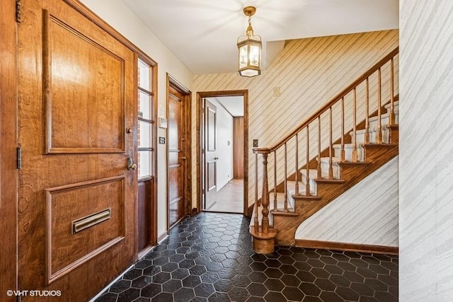 foyer entrance with dark tile patterned flooring and stairway