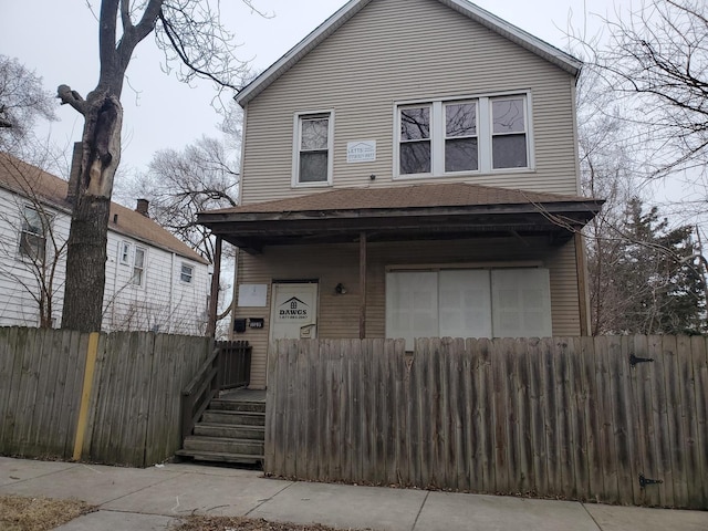 view of front facade featuring a porch and fence