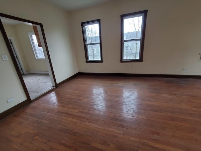 unfurnished room featuring baseboards and hardwood / wood-style floors