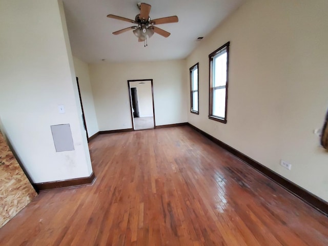 unfurnished room with ceiling fan, hardwood / wood-style floors, and baseboards