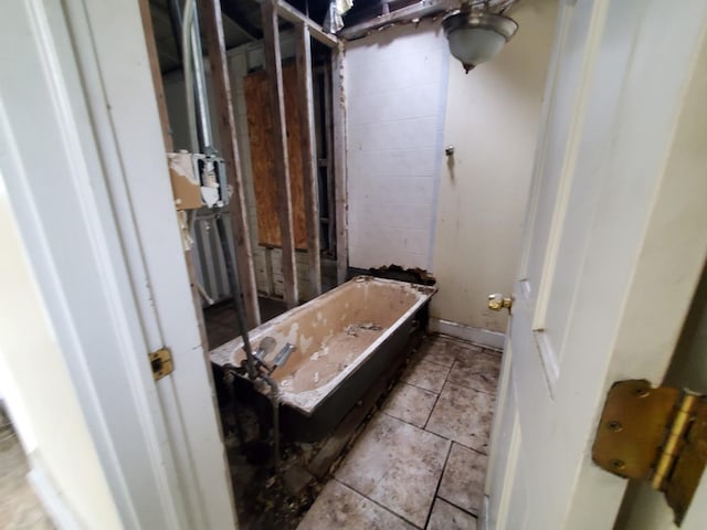 bathroom featuring tile patterned flooring and a freestanding bath