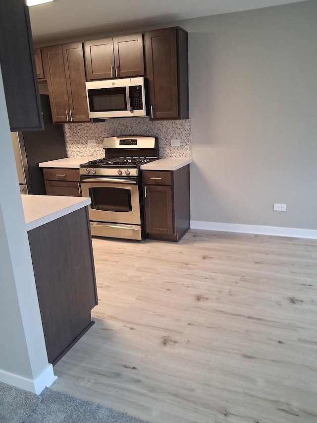 kitchen with appliances with stainless steel finishes, light countertops, and decorative backsplash