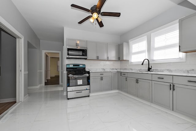 kitchen featuring marble finish floor, tasteful backsplash, appliances with stainless steel finishes, and gray cabinets