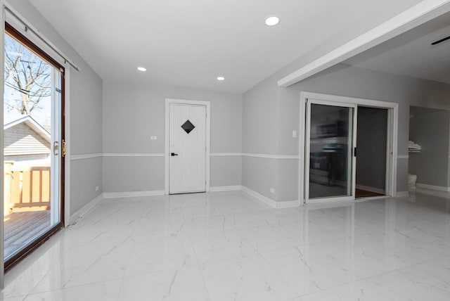 spare room with recessed lighting, marble finish floor, and baseboards