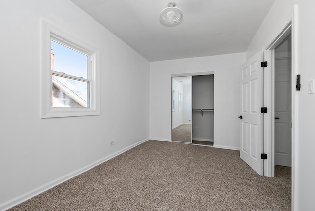 unfurnished bedroom with a closet, carpet flooring, and baseboards