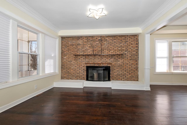 unfurnished living room featuring a brick fireplace, baseboards, crown molding, and wood finished floors