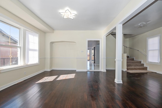 interior space with hardwood / wood-style flooring, stairs, baseboards, and ornate columns