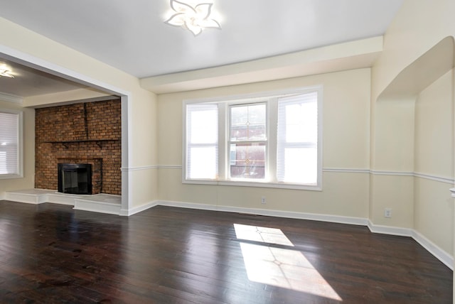 unfurnished living room with a fireplace, wood finished floors, and baseboards