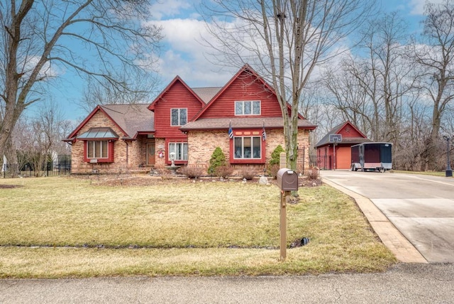 view of front of house featuring a shingled roof, a front yard, brick siding, and driveway