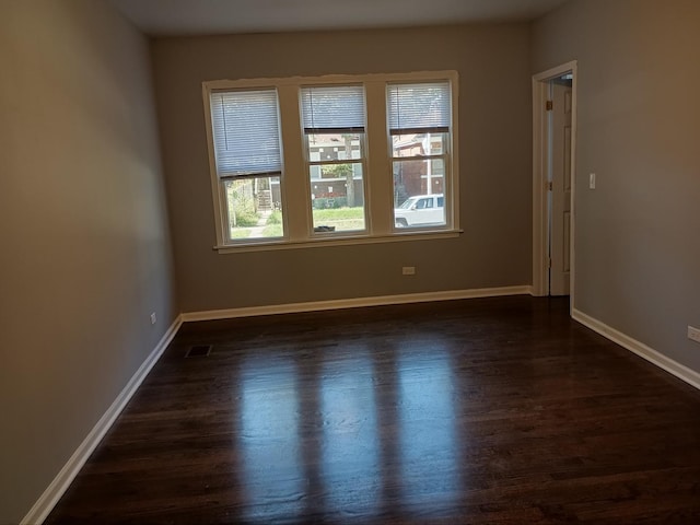 empty room with baseboards and dark wood-style flooring