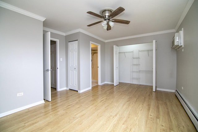 unfurnished bedroom with a baseboard radiator, light wood-type flooring, baseboards, crown molding, and multiple closets