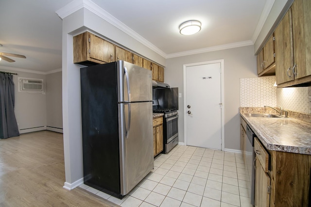 kitchen featuring appliances with stainless steel finishes, a sink, under cabinet range hood, ornamental molding, and tasteful backsplash