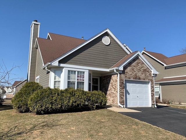 view of front of property with aphalt driveway, brick siding, a garage, and a front yard