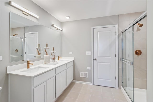 bathroom with a shower stall, visible vents, and a sink