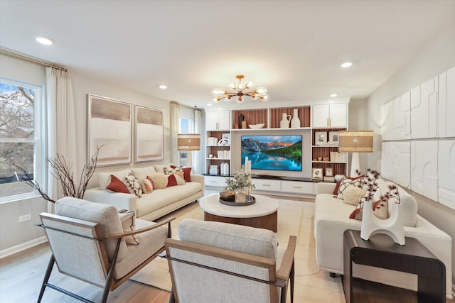 living room featuring a chandelier, built in shelves, light wood-style flooring, and recessed lighting