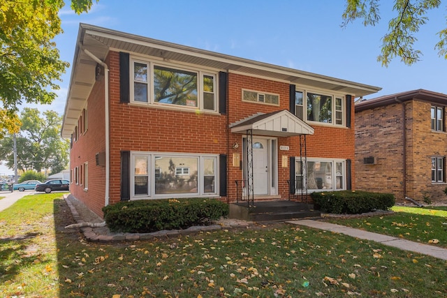 view of front of home featuring a front lawn and brick siding