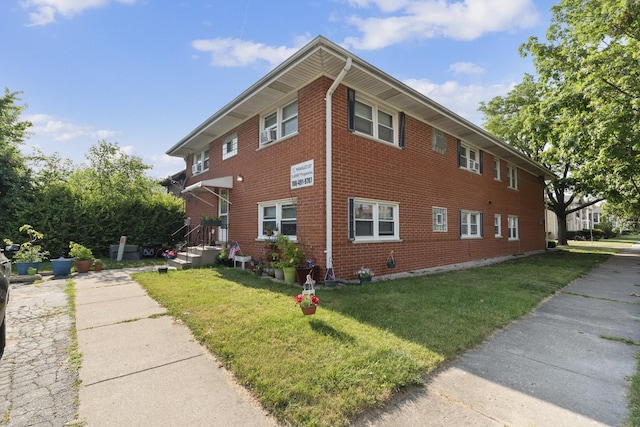 view of property exterior with brick siding and a lawn