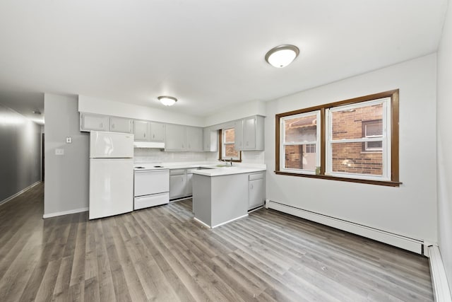 kitchen featuring white appliances, dark wood-style floors, a baseboard radiator, a peninsula, and light countertops