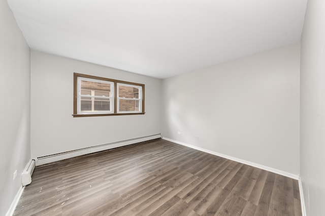 unfurnished room with a baseboard heating unit, baseboards, wood finished floors, and a baseboard radiator