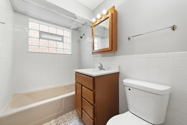 full bathroom featuring wainscoting, toilet, tile walls, and bathtub / shower combination