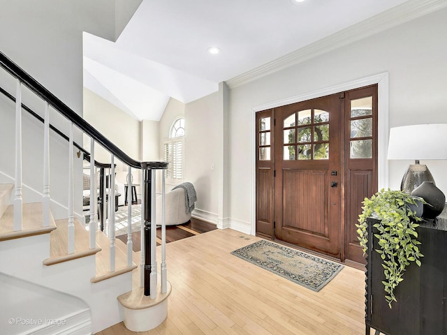 entryway featuring ornamental molding, wood finished floors, recessed lighting, baseboards, and stairs