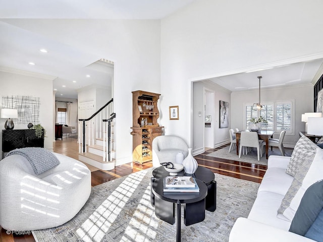 living room with recessed lighting, wood finished floors, stairs, and ornamental molding