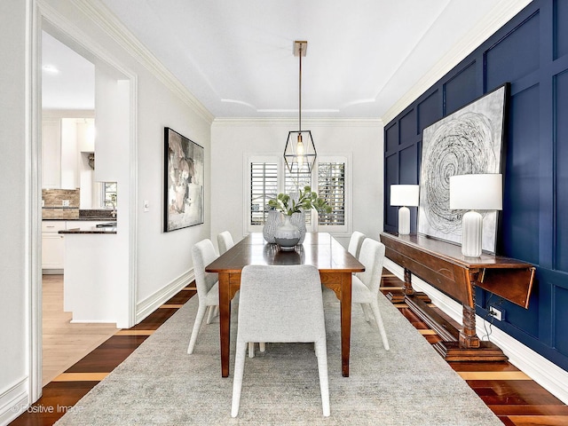 dining space with baseboards, dark wood-type flooring, and ornamental molding