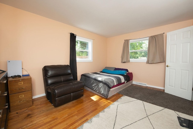 bedroom featuring baseboards, visible vents, and wood finished floors