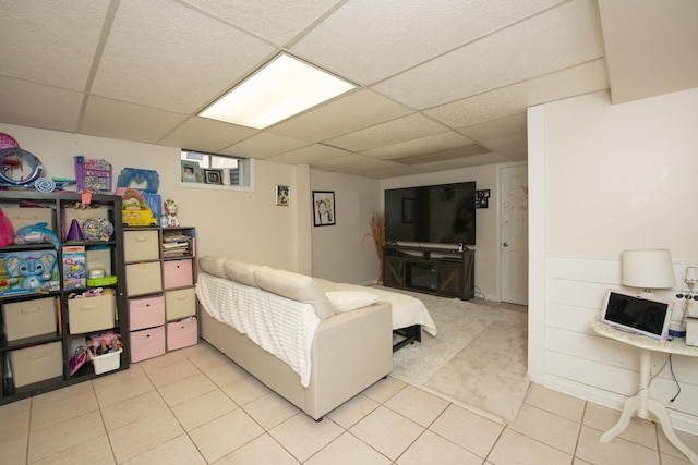 living room with light tile patterned floors and a drop ceiling