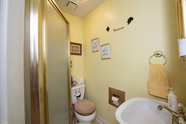 bathroom featuring toilet, a sink, visible vents, and baseboards