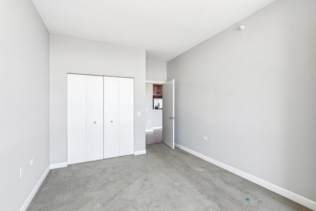 unfurnished bedroom with carpet floors, baseboards, and a closet