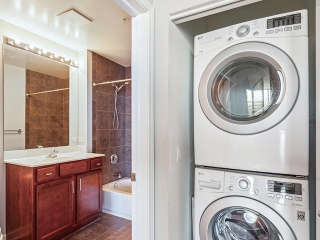 laundry room with laundry area, a sink, and stacked washer and clothes dryer