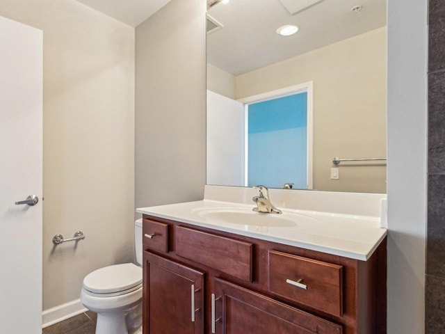 half bath featuring visible vents, toilet, vanity, tile patterned flooring, and baseboards