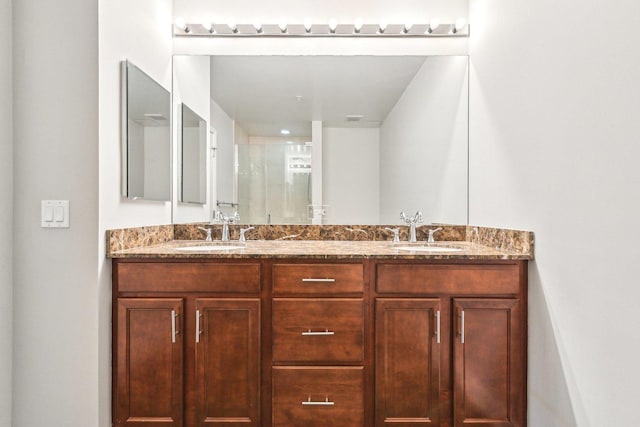 bathroom featuring a sink, a shower stall, and double vanity